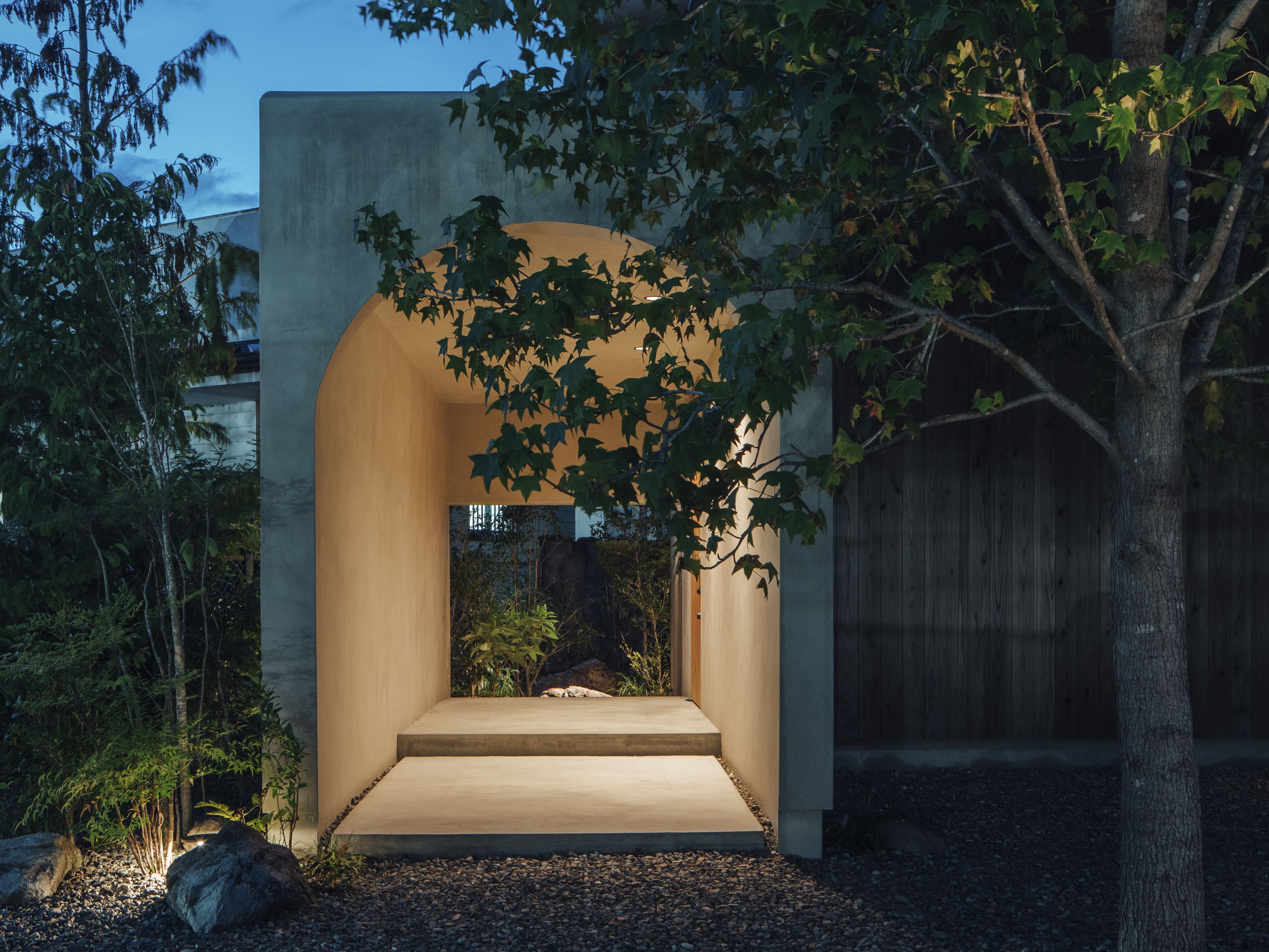 夜の玄関アプローチ、コンクリートアーチから漏れる暖かな光